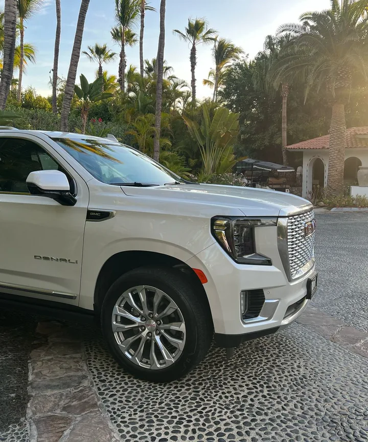 White GMC Yukon Denali for private airport transfers at a resort entrance in Los Cabos
