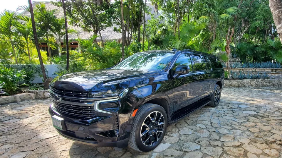 Black Chevrolet Suburban for private airport transfers at a jungle resort entrance in the Riviera Maya