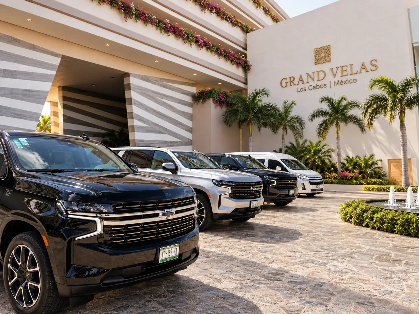 Blue Dreams Suburbans and Van lined up at a resort entrance in Los Cabos