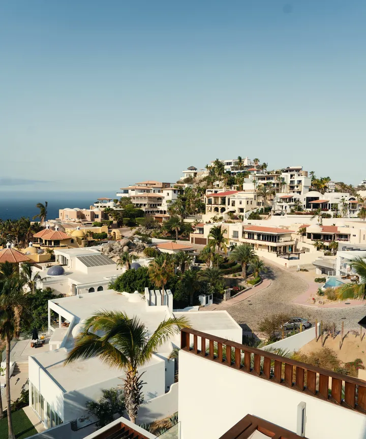 White hillside villas with palm trees overlooking the ocean in the Pedregal area of Cabo San Lucas